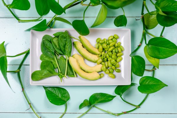 Healthy greens on a white plate - plant based diet concept