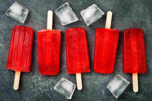 Homemade frozen blood orange natural juice alcoholic popsicles - paletas - ice pops. Overhead, flat lay, top view, copy space