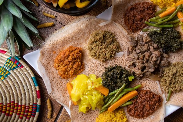 A high angle shot of the ingredients of traditional Ethiopian food on loaves of bread