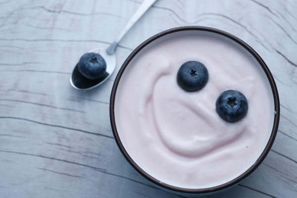 A delightful yogurt bowl filled with fresh blueberries, creating a cheerful smiley face